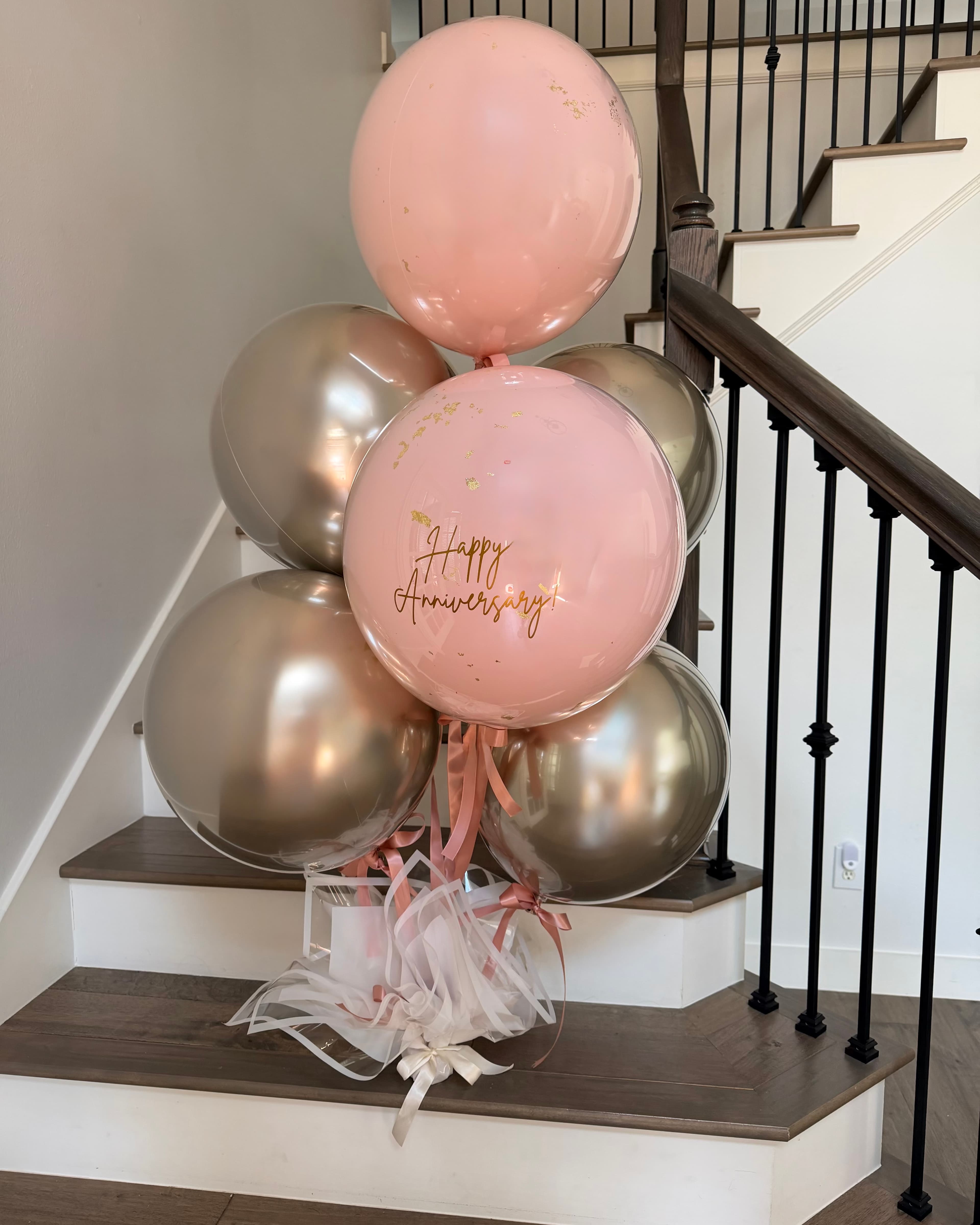 Signature Luxury Helium: six double-stuffed balloons with a clear overlay on a wrapped base, tied with a large statement bow